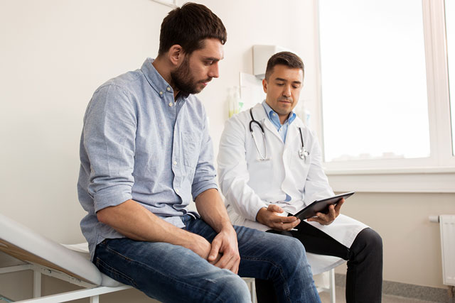 Der Arzt erklärt dem Patienten die Schritte, die bei einer Herzerkrankung zu befolgen sind. Hören sie auf ihr herz